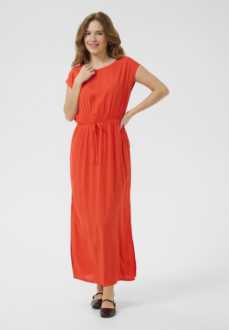 Long, flowing red dress with short sleeves, elastic waist, and drawstring detail. Smooth fabric with side slits for ease of movement.