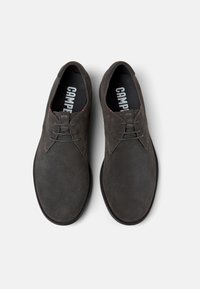 Šedé semišové šněrovací boty s hladkým povrchem, kulatou špičkou a minimalistickým designem. Uvnitř označené "CAMPER."