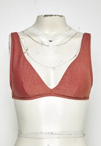 Sutiã vermelho brilhante com um design de decote em V profundo, alças largas e textura suave. Apresenta um acabamento liso e detalhes de construção minimalistas.