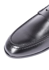 Mocassino in pelle nera con punta arrotondata, caratterizzato da dettagli di cucitura discreti e una finitura liscia e lucida.