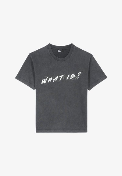 T-shirt à manches courtes gris foncé avec un imprimé de texte blanc en détresse qui indique « QUE QUOI ? » à l'avant. Matière en coton, coupe standard.