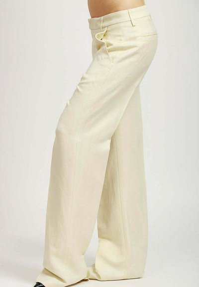 Pantalones de pierna ancha fabricados en una tela ligera de un suave color crema. Presentan una cintura ajustada, bolsillos laterales y una textura suave.