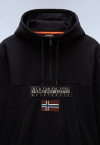 Sudadera con capucha azul marino con cierre de media cremallera, que presenta un parche de logo gris y un acento de la bandera de Noruega en el pecho. Material de algodón.