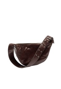 Brązowa skórzana torba na ramię o zakrzywionym kształcie, z zamknięciem na zamek błyskawiczny i szerokim paskiem z metalowymi elementami i okrągłymi wycięciami.
