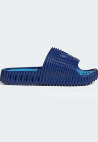 Blå gummiramp med horisontell ribbad textur och ett utskärningsdesign. Interiören har en kontrasterande ljusblå färg. Öppen tå och baksida.