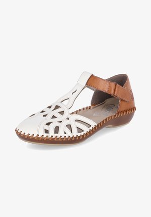 White and brown leather sandal with cut-out design, T-strap, brown accent and stitched detailing along the sole. Rounded toe shape.