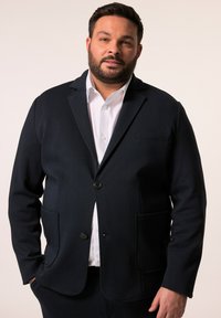 Marinblå blazer tillverkad av texturerat tyg med kurgleskrage, två framfickor, enknappsstängning och en slim fit-design.