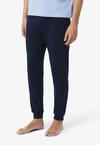 Joggeurs bleu marine en tissu doux, avec une jambe fuselée, des poignets élastiques et une taille confortable.