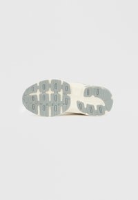 Talpă de pantof în gri deschis și crem; prezintă o suprafață texturată de cauciuc cu un model de șanțuri și proeminențe pentru tracțiune.