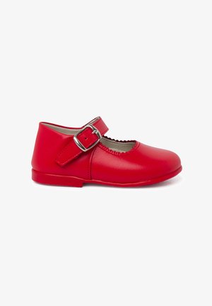 Chaussure Mary Jane en cuir rouge avec un bout rond, bord décoratif découpé, bride réglable avec boucle et semelle plate basse.