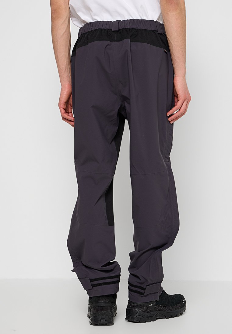 Grijze waterdichte broek met een zwarte elastische tailleband, voorzien van zijzakken en zwarte paneelaccenten op de benen. Textuurstof met verstelbare boorden.