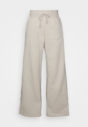 Beige wide-leg sweatpants made from soft fabric, featuring a drawstring waist and a small white logo on the left side.
