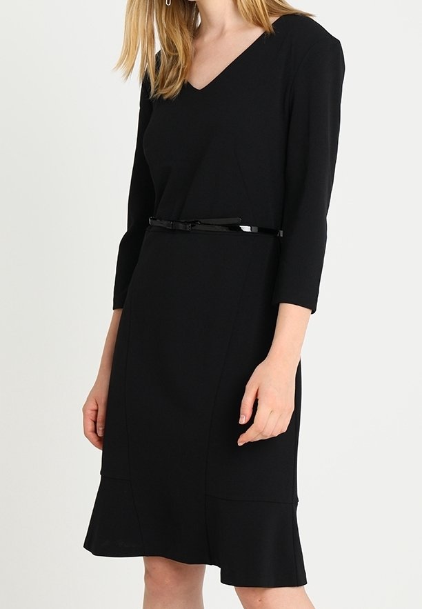 Svart knälång klänning med trekvartslånga ärmar, V-ringning, figurnära midja, utsvängd nederkant och ett smalt svart bälte i midjan.