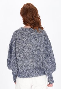 Grauer und blauer Strickpullover mit einem strukturierten Strickmuster, entspannt geschnitten und mit Puffärmeln, von hinten betrachtet.