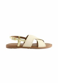 Beige Leder-Sandalen mit Kreuzdesign, verstellbarem goldfarbenem Schnallenverschluss, flacher brauner Sohle und offenen Zehen, geeignet für legere Anlässe.