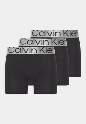 Tričkočierne elastické bavlnené boxerky v trojici s strieborným elastickým pásom, na ktorom je výrazným čiernym písmom logo "Calvin Klein".