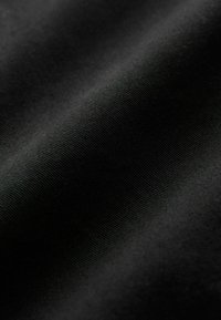 Fekete szövet, sima textúrával, enyhe bordázott mintázattal. Az anyag puhanak és hajlékonyan tűnik, egységes színnel.