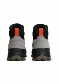 Stivaletti alla caviglia in suede grigio e mesh nero con linguetta arancione, caratterizzati da una suola esterna nera e robusta con gomma strutturata per una migliore aderenza.