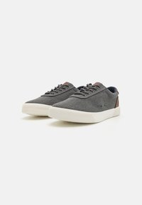 Gray fabric sneakers with white rubber soles, featuring a rounded toe, lace-up design, and brown accents near the heel.