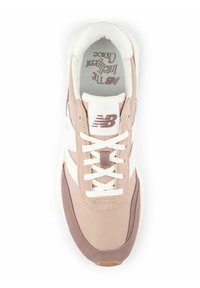Vista superior de una zapatilla New Balance en rosa y blanco con cordones blancos y el logotipo de la marca visible en la lengua y la plantilla.