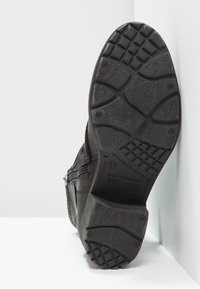 Černá bota s texturovaným svrškem, která má zipový detail. Guminová podrážka s vzorovaným šlápnutím pro trakci a stabilitu. Velikost 37.