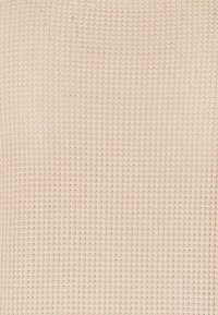 Beżowa tkanina o fakturze z wzorem kratki, z małymi, równomiernie rozmieszczonymi kwadratami. Miękki materiał z przewiewnym designem.