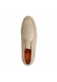 Chaussure en suède beige avec un bout arrondi, deux œillets et des détails en lacet. L'intérieur présente une doublure en cuir marron. Texture lisse et mate sur l'ensemble.