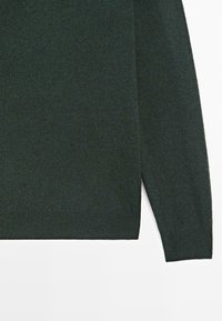 Tmavě zelený pletený svetr s jemnou texturou, s dlouhými rukávy a rovným střihem spodního lemu. Látka působí lehce a prodyšně.