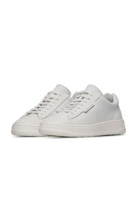Sneakers bianche in pelle con texture liscia, punta tonda e design a bassa altezza. Presentano un sistema di chiusura con lacci e un marchio discreto sul lato.