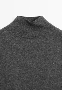 Grauem Rollkragenpullover mit weichem, geripptem Textur und schmalem Hals, mit glatter Oberfläche und ohne ausgeprägte Muster oder Designs.