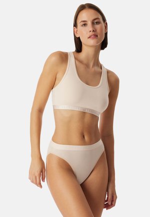 Beige sportbeha en hoog uitgesneden slipje, gemaakt van gladde stof met een brede elastische band met subtiele branding.