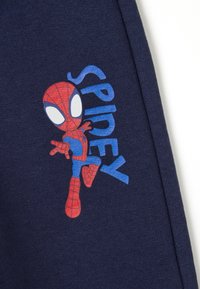 Marine stof met een Spider-Man karakterafbeelding in rood en blauw, met het woord "SPIDEY" in bold blauwe letters ernaast.