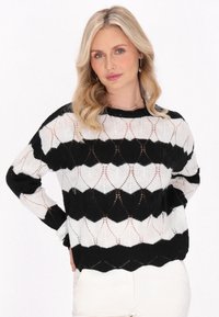 Maglione a righe bianco e nero con motivo a scallop, realizzato in un materiale knit leggero. Presenta maniche lunghe e un collo rotondo.