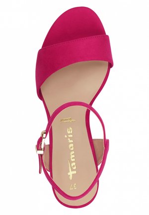 Fuchsia suède hoge hak sandaal met open teen en enkelbandje. Voorzien van een gepolsterde binnenzool en gouden logo detail.