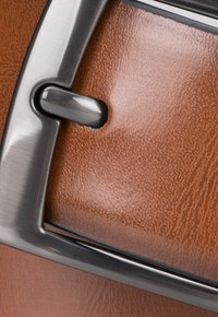Brązowa skórzana powierzchnia o fakturze, z metalową srebrną klamrą, charakteryzująca się smukłym, prostokątnym kształtem i wypolerowanym wykończeniem elementów metalowych.