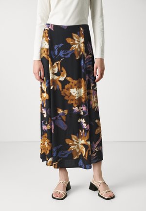 Fustă lungă și fluidă de culoare neagră, cu modele florale mari în nuanțe de maroniu, auriu și violet. Material neted; asociată cu sandale bej cu bretele.
