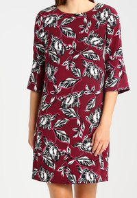 Robe à manches courtes en tissu bordeaux avec un motif floral noir et blanc. Coupe droite avec un col rond. Texture lisse.
