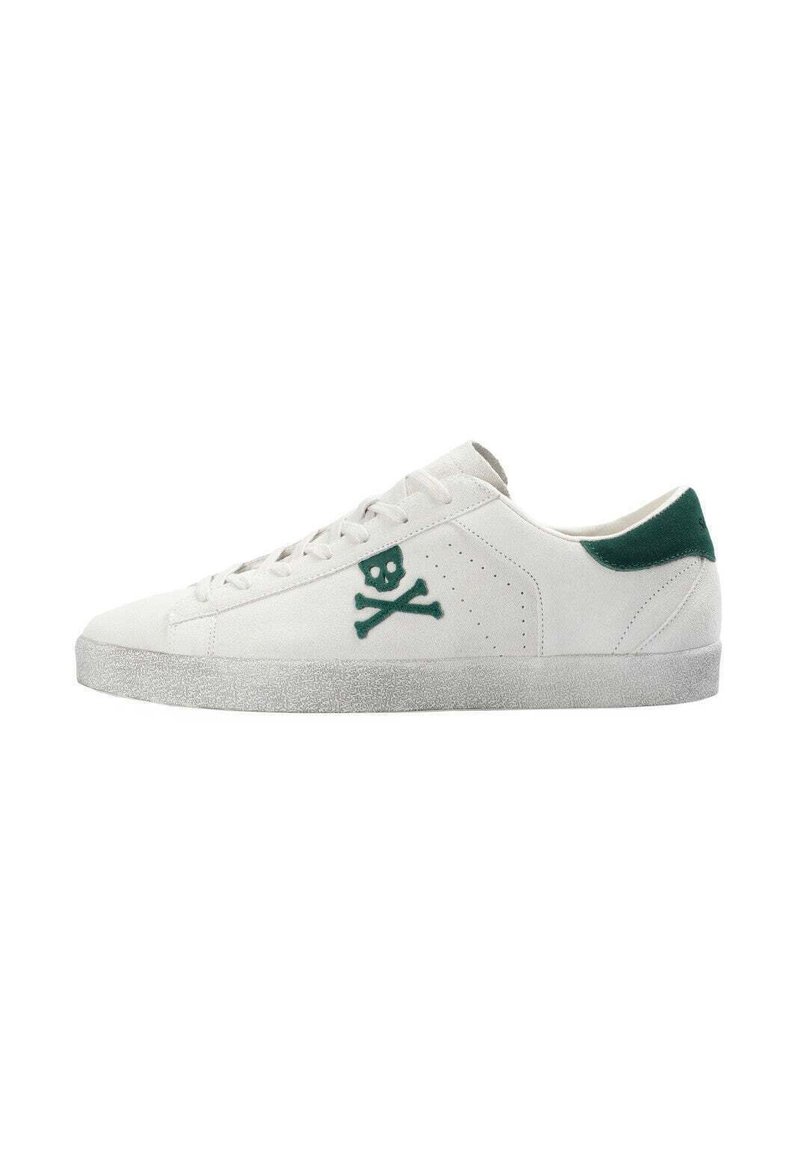 Zapatilla de ante blanca con un tabique de talón de ante verde, que presenta un logo de calavera y huesos cruzados verde en el costado y una suela de goma texturizada gris.