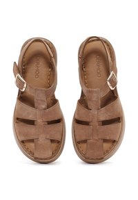 Sandal in suede marrone con punta chiusa, design con tallone aperto e cinturino regolabile con fibbia metallica. Parte superiore texturizzata con cinturini incrociati.