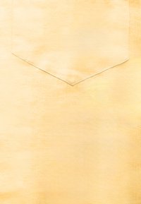 Tissu jaune clair avec une poche triangulaire surpiquée centrée dans le cadre.