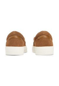 Paire de chaussures en daim marron sans lacets avec semelles en caoutchouc blanches vue de dos sur fond blanc.