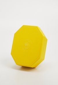 Lys gul oktagonal gjenstand laget av teksturert materiale med et hevet svanemblem i sentrum.