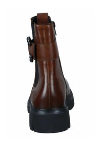 Bottine en cuir marron avec une finition texturée, fermeture éclair sur le côté et quincaillerie décorative noire. Semelle épaisse noire pour plus de stabilité.