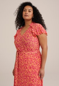 Rochie cu decolteu în V, de culoare roz aprins, cu un model floral galben, având mâneci volănaș și talie legată, confecționată dintr-un material texturat ușor.