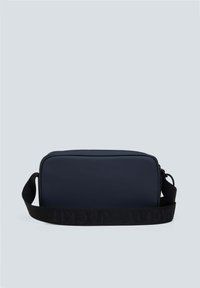 Borsa rettangolare blu navy realizzata in materiale liscio, con una larga tracolla nera con branding in rilievo lungo tutta la lunghezza. Chiusura con zip nella parte superiore.