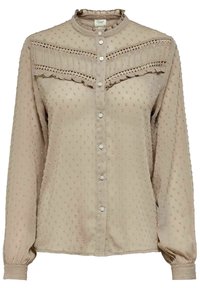 Beige Bluse mit langen Ärmeln aus strukturiertem Stoff, mit Rüschendetails, Knopfschluss und dekorativen Nähten an Brust und Schultern.