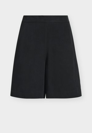 Μαύρες σορτς με φαρδιά μπατζάκια μέχρι το γόνατο, με εφαρμοστό ζωνάκι και καθαρό, μινιμαλιστικό σχέδιο σε ουδέτερο φόντο.