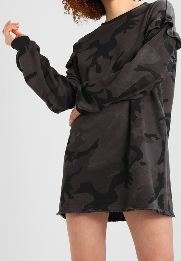 Lös passform, långärmad klänning i mörkgrå med svart kamouflage-mönster. Har rå kant och textil med subtila detaljer på ärmarna.