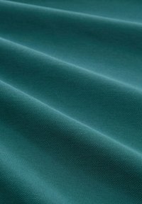 Strukturiertes petrolfarbenes Gewebe mit einer glatten Oberfläche, das zarte Wellen und ein gleichmäßiges Webmuster aufweist, geeignet für Polsterungen oder Bekleidung.
