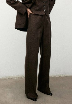 Brązowe spodnie garniturowe z mieszanki wełny o szerokim kroju nogawki, wysokim pasie i eleganckich szwach, w połączeniu z dopasowaną marynarką w tym samym kolorze.
